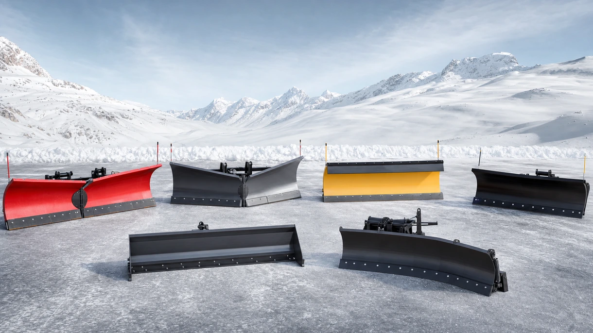Professioneller Traktor, ausgestattet mit einem Hochleistungs-Schneeschild, bei der Räumung tiefer Schneeverwehungen auf einem großen landwirtschaftlichen Betriebsgelände.
