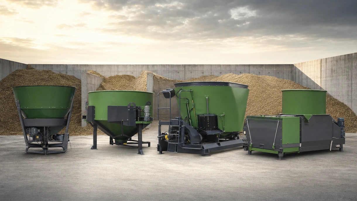 Industrial stationary mixing wagon discharging TMR feed onto a belt conveyor in a modern dairy cattle barn environment.